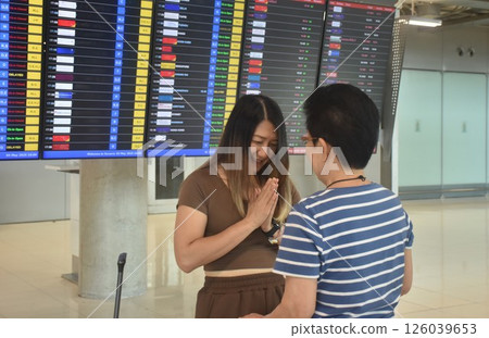 Thai daughter pay respect to mother for good bye before flight in airport 126039653
