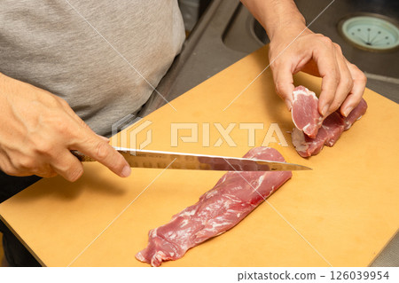一位男廚師將豬裡肌肉切成小塊 126039954
