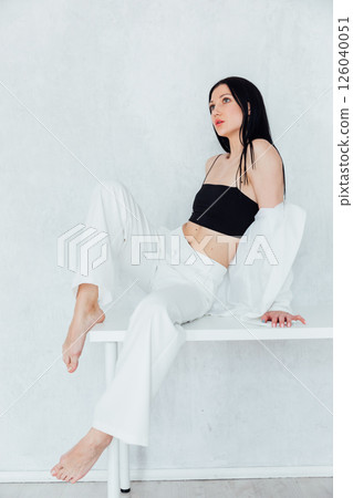Beautiful fashion brunette woman in light suit in white room interior Beautiful fashion brunette woman in light suit in white room interior 126040051