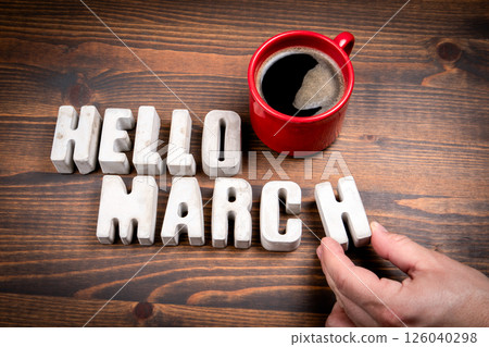 Hello March. Concrete alphabet letters and coffee mug on dark wooden texture background Hello March. Concrete alphabet letters and coffee mug on dark wooden texture background 126040298