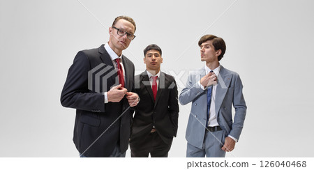 Confident businessmen in suits stand against white backdrop, embodying business professionalism and policy influence. Confident businessmen in suits stand against white backdrop, embodying business professionalism and policy influence. 126040468