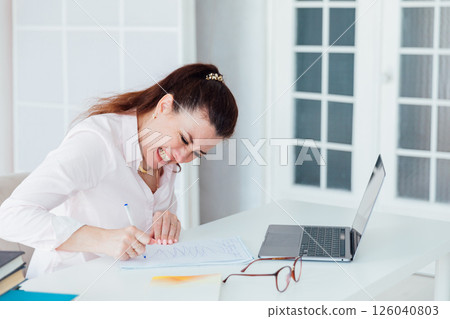 woman nervous writing at office desk with laptop woman nervous writing at office desk with laptop 126040803