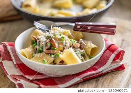 Typical Italian pasta Calamarata with bacon, fresh peas and parmesan cheese 126040971