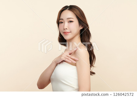 A beautiful young Asian woman with clean, fresh skin against a beige background. Skincare, facial treatment, cosmetology, beauty, and spa. An elegant portrait of an Asian woman. A beautiful young Asian woman with clean, fresh skin against a beige background. Skincare, facial treatment, cosmetology, beauty, and spa. An elegant portrait of an Asian woman. 126042572