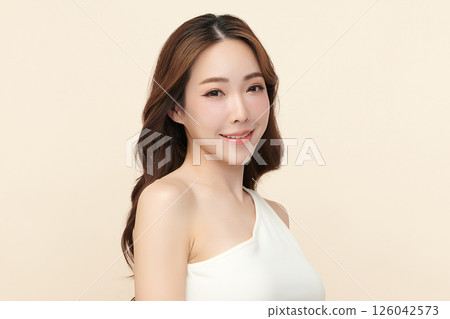 A beautiful young Asian woman with clean, fresh skin against a beige background. Skincare, facial treatment, cosmetology, beauty, and spa. An elegant portrait of an Asian woman. A beautiful young Asian woman with clean, fresh skin against a beige background. Skincare, facial treatment, cosmetology, beauty, and spa. An elegant portrait of an Asian woman. 126042573