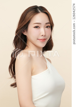 A beautiful young Asian woman with clean, fresh skin against a beige background. Skincare, facial treatment, cosmetology, beauty, and spa. An elegant portrait of an Asian woman. A beautiful young Asian woman with clean, fresh skin against a beige background. Skincare, facial treatment, cosmetology, beauty, and spa. An elegant portrait of an Asian woman. 126042574