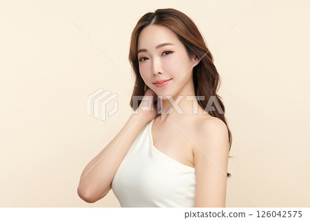 A beautiful young Asian woman with clean, fresh skin against a beige background. Skincare, facial treatment, cosmetology, beauty, and spa. An elegant portrait of an Asian woman. A beautiful young Asian woman with clean, fresh skin against a beige background. Skincare, facial treatment, cosmetology, beauty, and spa. An elegant portrait of an Asian woman. 126042575
