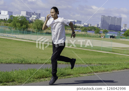 A young man running along the bank of the Tama River A young man running along the bank of the Tama River 126042996