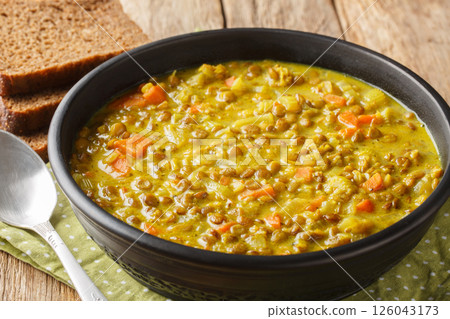 Vegan detox lentil soup with coconut milk, carrot, onion, turmeric, lemon and ginger close-up in a plate. Horizontal Vegan detox lentil soup with coconut milk, carrot, onion, turmeric, lemon and ginger close-up in a plate. Horizontal 126043173