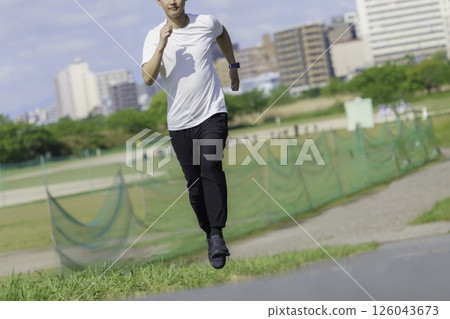 A young man running along the bank of the Tama River A young man running along the bank of the Tama River 126043673