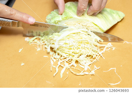 Stock photo of a man cutting cabbage 126043693