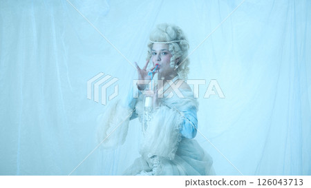 Elegant young woman as medieval royal person sipping milk with straw against light blue background. Elegant young woman as medieval royal person sipping milk with straw against light blue background. 126043713