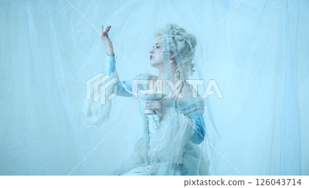 Young graceful woman as medieval duchess in vintage corset raising pearl necklace against light blue background. Young graceful woman as medieval duchess in vintage corset raising pearl necklace against light blue background. 126043714
