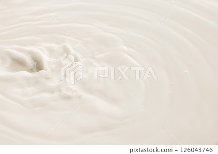White milk swirls in soft circular motion with textured surface and natural flow. 126043746