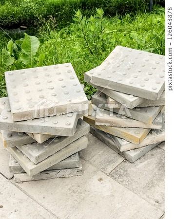 Two stacks of sidewalk tile in the street on a summer day, preparing to repair the pedestrian area 126043878