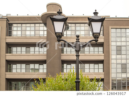 Beautiful street lamp with two lamps on the background of the facade of a modern building Beautiful street lamp with two lamps on the background of the facade of a modern building 126043917