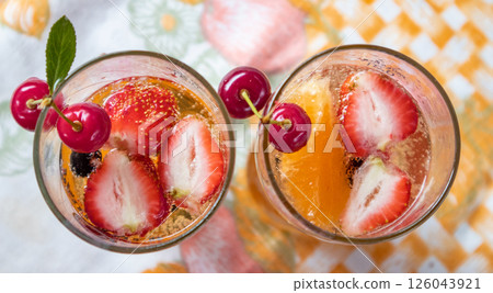 Summer cocktail with strawberries, cherries and frothy champagne, top view Summer cocktail with strawberries, cherries and frothy champagne, top view 126043921