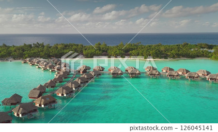 Aerial view of idyllic overwater bungalows in Bora Bora, French Polynesia, set against turquoise lagoon and lush tropical island. Wild travel destination, remote nature paradise, exotic summer travel 126045141