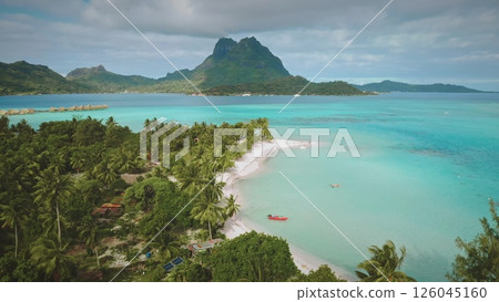 Beauty of Bora Bora island beach, with turquoise crystal water lagoon, coconut palm trees, and iconic mount otemanu in background. Remote wild nature paradise, exotic summer travel. Aerial drone shot 126045160