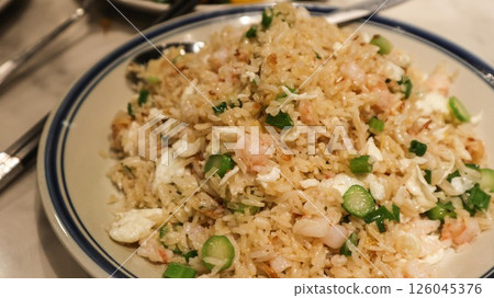 Close up of golden colour Chinese egg fried rice with egg white, shrimp, choi sum vegetables on a plate 126045376