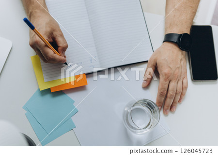 Close up, business man using mobile smart phone and and makes notes in a notebook. makes an appointment, conducts a consultation, social network 126045723