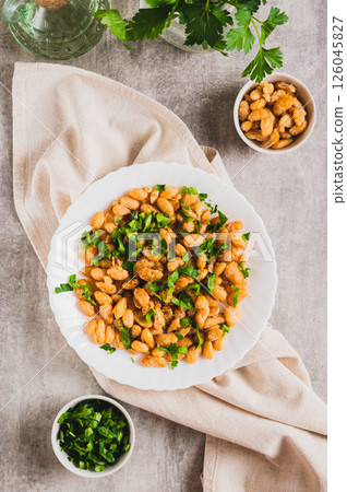 Homemade fried white beans and greens salad on plate on table top and vertical view Homemade fried white beans and greens salad on plate on table top and vertical view 126045827