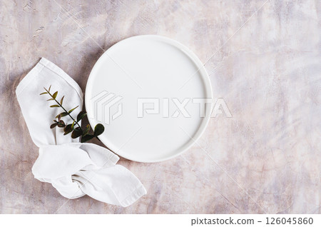Empty white ceramic plate, branch and napkin on light background top view Empty white ceramic plate, branch and napkin on light background top view 126045860