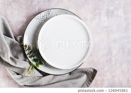 Pair of empty ceramic plates with napkin on gray background top view Pair of empty ceramic plates with napkin on gray background top view 126045861