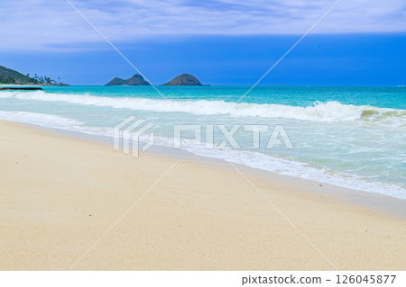 Hawaiian holidays: blue sky, ocean and white sand beaches. Mokulua Islands as seen from Bellows Beach on Oahu. Hawaiian holidays: blue sky, ocean and white sand beaches. Mokulua Islands as seen from Bellows Beach on Oahu. 126045877