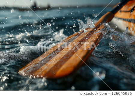 Wooden paddle splashing water during kayaking Wooden paddle splashing water during kayaking 126045956