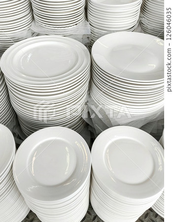 Stacks of clean, white plates ready for use in a commercial setting. Stacks of clean, white plates ready for use in a commercial setting. 126046035