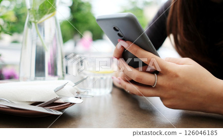 Girl Surfing On Internet On A Smartphone While Waiting In Cafe Girl Surfing On Internet On A Smartphone While Waiting In Cafe 126046185