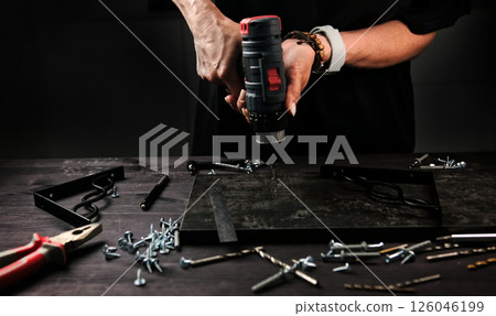 female carpenter drilling wooden planks in workshop 126046199