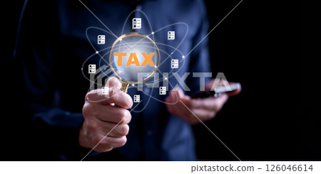 Concept of tax payment optimisation business finance,Man holds a magnifying glass and taxes icon on technology screen,income tax and property, background for business, individuals and corporations suc 126046614