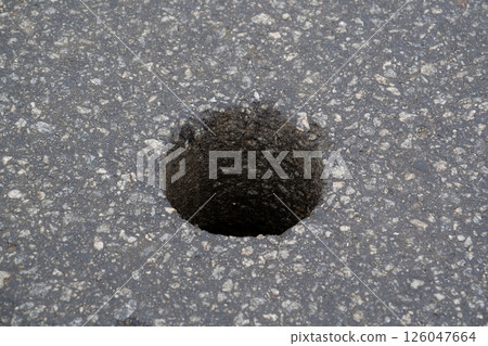 Round hole in the asphalt to check the quality of the roadway Round hole in the asphalt to check the quality of the roadway 126047664