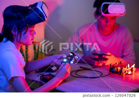 Young man and young woman amateur inventor testing electronic device model inventions 126047826