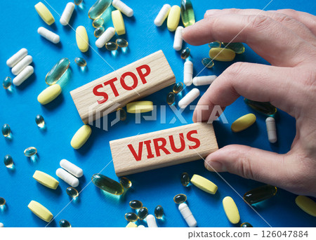 Stop Virus symbol. Concept word Stop Virus on wooden blocks. Beautiful blue background with pills. Doctor Hand. Medicine and Stop Virus concept. Copy space Stop Virus symbol. Concept word Stop Virus on wooden blocks. Beautiful blue background with pills. Doctor Hand. Medicine and Stop Virus concept. Copy space 126047884