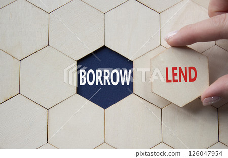 Lend or Borrow symbol. Concept word Lend or Borrow on wooden comb puzzle. Businessman hand. Beautiful deep blue background. Business and Lend or Borrow concept. Copy space Lend or Borrow symbol. Concept word Lend or Borrow on wooden comb puzzle. Businessman hand. Beautiful deep blue background. Business and Lend or Borrow concept. Copy space 126047954