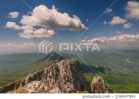 Man Climber Standing on Edge of Mountain Peak Man Climber Standing on Edge of Mountain Peak 126047991