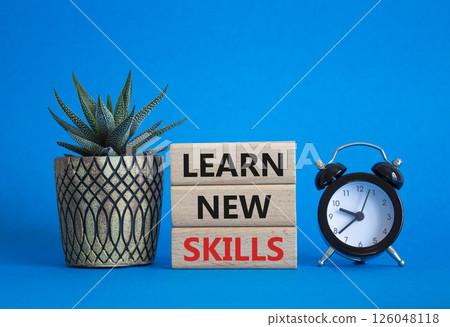 Learn new skills symbol. Concept words Learn new skills on wooden blocks. Beautiful blue background with succulent plant and alarm clock. Business and Learn new skills concept. Copy space. 126048118