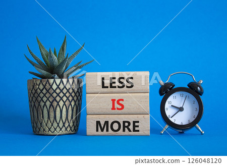 Less is More symbol. Concept words Less is More on wooden blocks. Beautiful blue background with succulent plant and alarm clock. Business and Less is More concept. Copy space. 126048120