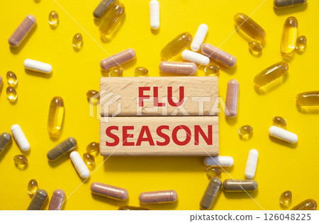 Flu Season symbol. Concept word Flu Season on wooden blocks. Beautiful yellow background with pills. Medicine and Flu Season concept. Copy space 126048225