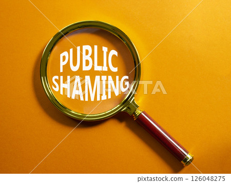 Public Shaming symbol. Magnifying glass with words Public Shaming. Beautiful orange background. Business and Public Shaming concept. Copy space. Public Shaming symbol. Magnifying glass with words Public Shaming. Beautiful orange background. Business and Public Shaming concept. Copy space. 126048275