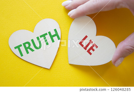 Truth or Lie symbol. Concept word Truth or Lie on wooden hearts. Businessman hand. Beautiful yellow background. Business and Truth or Lie concept. Copy space 126048285