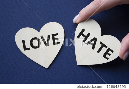 Love vs Hate symbol. Concept word Love vs Hate on wooden hearts. Businessman hand. Beautiful deep blue background. Business and Love vs Hate concept. Copy space 126048293
