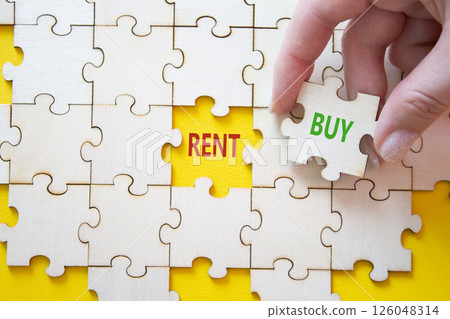 Rent or Buy symbol. Concept word Rent or Buy on wooden puzzle. Businessman hand. Beautiful yellow background. Business and Rent or Buy concept. Copy space Rent or Buy symbol. Concept word Rent or Buy on wooden puzzle. Businessman hand. Beautiful yellow background. Business and Rent or Buy concept. Copy space 126048314