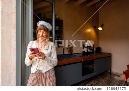 Peaceful moment with phone in Sicilian rustic kitchen Peaceful moment with phone in Sicilian rustic kitchen 126048375
