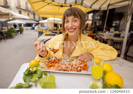Happy woman enjoying Sicilian pasta 126048433