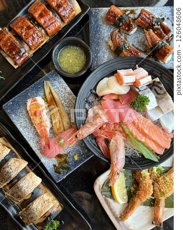 vertical photos shrimp eel Sushi Set sashimi and sushi rolls served on stone slate 126048606