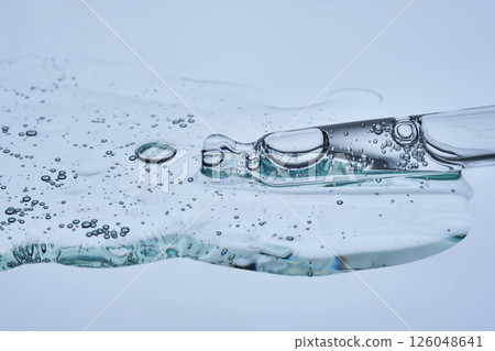 A facial serum with microneedles and a pipette on a blue background. The texture. 126048641